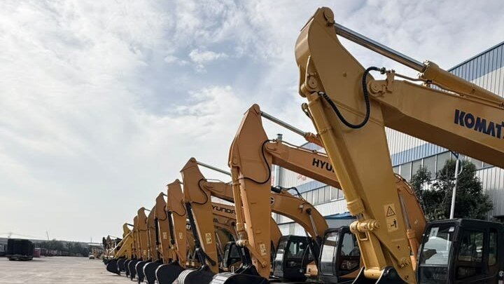 Row of yellow crawler excavators lined up in an equipment yard in China