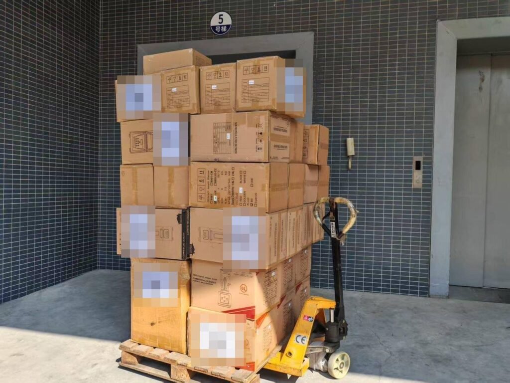 A pallet stacked with packed cartons beside a pallet truck, ready for shipment